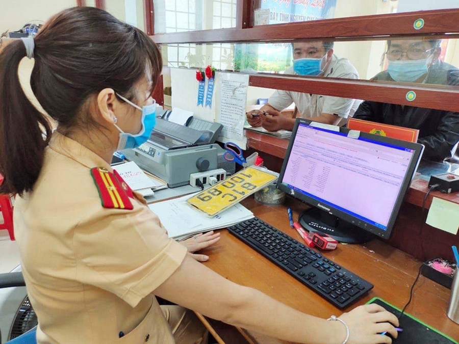 Cán bộ Phòng Cảnh sát Giao thông (Công an tỉnh) cấp biển số xe cho người dân. Ảnh: H.V