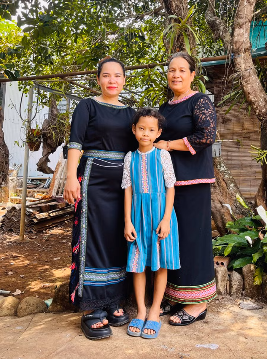 Bà Phưl (ngoài cùng bên phải) tự may các sản phẩm thổ cẩm cách tân để mình và con, cháu trong gia đình mặc. Ảnh: N.H