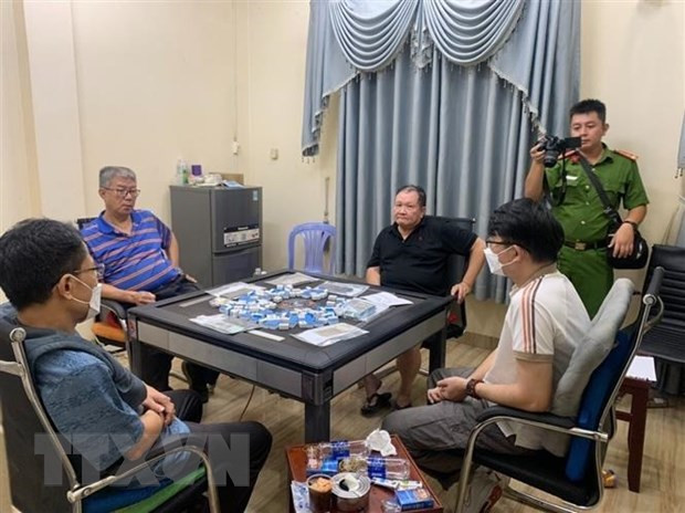 Các đối tượng bị bắt giữ cùng tang vật. (Ảnh: TTXVN phát) Các đối tượng bị bắt giữ cùng tang vật. (Ảnh: TTXVN phát)