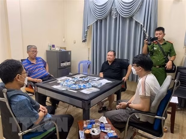 Các đối tượng bị bắt giữ cùng tang vật. (Ảnh: TTXVN phát) Các đối tượng bị bắt giữ cùng tang vật. (Ảnh: TTXVN phát)