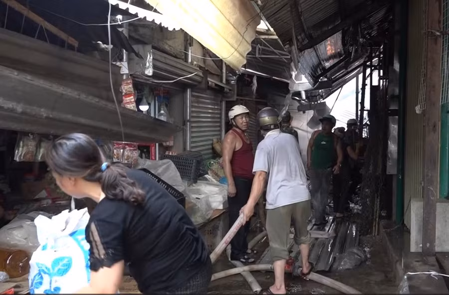 Tiểu thương bên trong chợ giúp nhau di chuyển đồ đạc, tránh thiệt hại. Ảnh: Bảo Trung