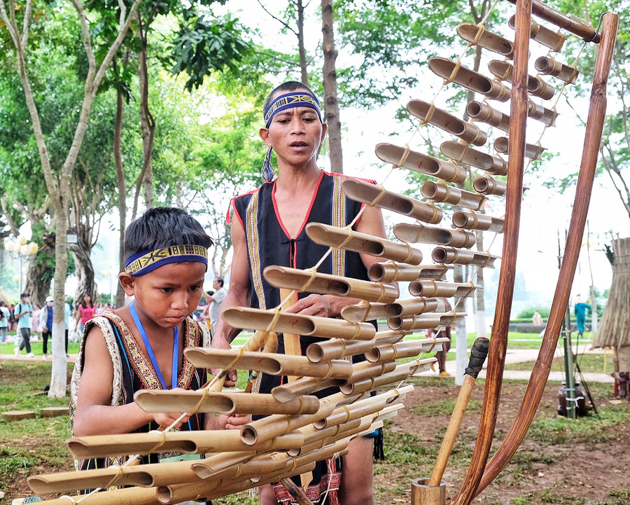 Anh Tum và con trai Hu Xy bên cây đàn t'rưng. Ảnh: Hoàng Ngọc Anh Tum và con trai Hu Xy bên cây đàn t'rưng. Ảnh: Hoàng Ngọc