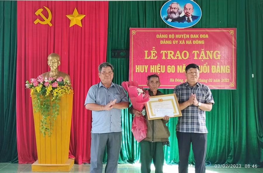 Chủ tịch Ủy ban MTTQ Việt Nam tỉnh Hồ Văn Điềm (bìa trái) tặng hoa và quà chúc mừng đảng viên nhận Huy hiệu 60 năm tuổi Đảng. Ảnh: Lê Đại