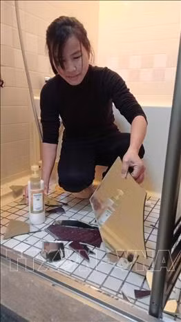 Chị Lê Thị Dậu - một lao động Việt Nam đang dọn dẹp vật dụng trong nhà bị hư hại do động đất. Ảnh: TTXVN Chị Lê Thị Dậu - một lao động Việt Nam đang dọn dẹp vật dụng trong nhà bị hư hại do động đất. Ảnh: TTXVN