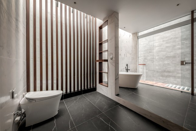 Phòng vệ sinh hiện đại với bồn tắm và khu vực vệ sinh được ngăn cách.