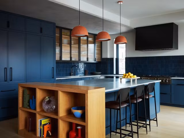Yêu thích phong cách phóng khoáng, mang “hơi thở” của biển cả thì màu xanh dương chính là gam màu chủ đạo trong căn phòng bếp của gia đình bạn. Phối chúng cùng đèn thả trần màu cam, kệ gỗ sáng màu và tủ bếp trong suốt sẽ đem tới lối kiến trúc hiện đại và bắt mắt vô cùng.