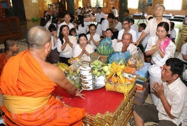 Người dân Campuchia thực hiện nghi thức cúng dường chư tăng tại tại Chùa Svay Romeat tỉnh Siem Reap. (Ảnh: AKP/TTXVN)