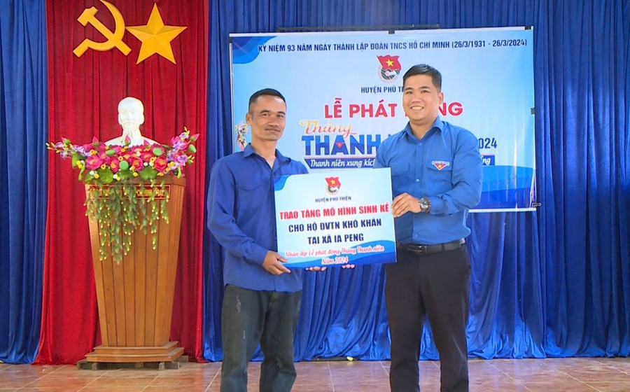 Anh Nguyễn Thành Hưng (bìa phải)-Phó Bí thư Huyện Đoàn Phú Thiện trao mô hình sinh kế cho thanh niên xã Ia Peng. Ảnh: M.N