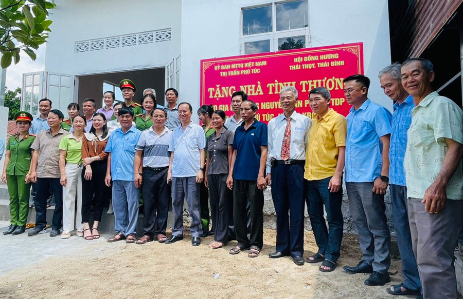 Hội đồng hương huyện Thái Thụy (tỉnh Thái Bình) tại Gia Lai bàn giao nhà tình nghĩa cho gia đình ông Nguyễn Văn Phong (thứ 6 từ phải sang, tổ dân phố 10, thị trấn Phú Túc). Ảnh: Vũ Chi