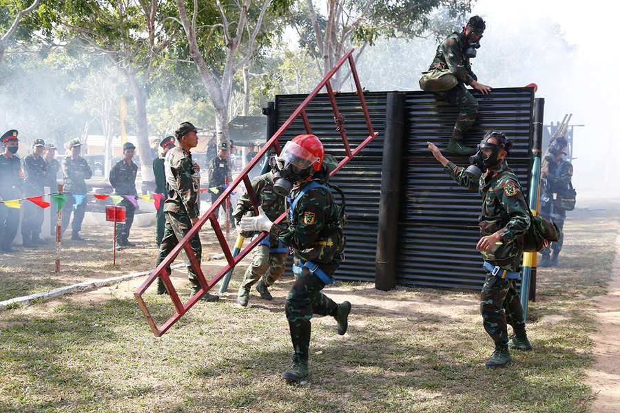 Các vận động viên thực hiện phần thi vượt chướng ngại vật trong điều kiện phải đeo thiết bị phòng độc. Ảnh: Vĩnh Hoàng Các vận động viên thực hiện phần thi vượt chướng ngại vật trong điều kiện phải đeo thiết bị phòng độc. Ảnh: Vĩnh Hoàng