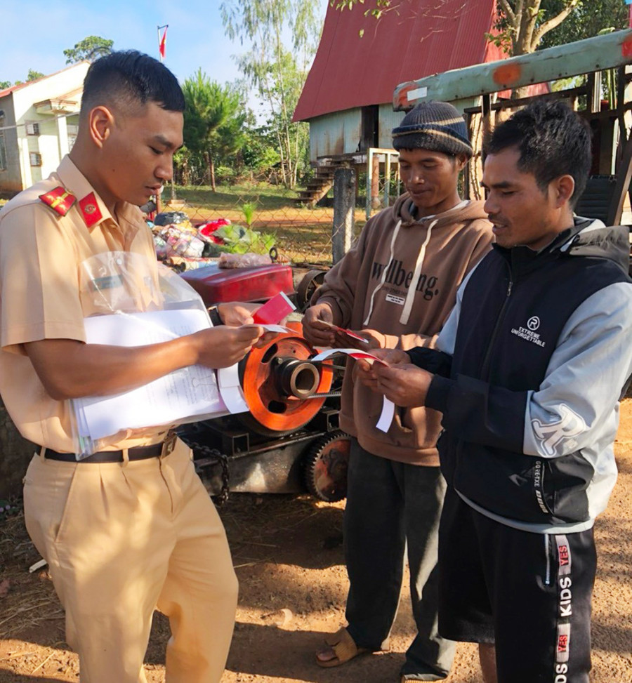 Công an huyện Chư Păh tuyên truyền, hướng dẫn người dân lắp đặt biển phản quang trên xe công nông. Ảnh: R.H Công an huyện Chư Păh tuyên truyền, hướng dẫn người dân lắp đặt biển phản quang trên xe công nông. Ảnh: R.H