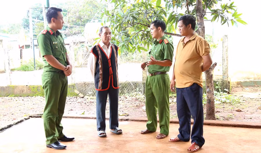 Cán bộ Công an xã Ia Chía (huyện Ia Grai) trao đổi với già làng Rơ Châm Chích (làng Peng) về công tác tuyên truyền, vận động người dân nâng cao ý thức phòng-chống ma túy. Ảnh: H.T