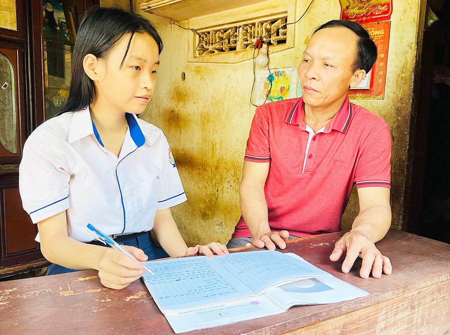 Thầy Phạm Văn Quyết hướng dẫn em Nguyễn Thị Thúy Nga ôn tập kiến thức. Ảnh: Phan Lài Thầy Phạm Văn Quyết hướng dẫn em Nguyễn Thị Thúy Nga ôn tập kiến thức. Ảnh: Phan Lài
