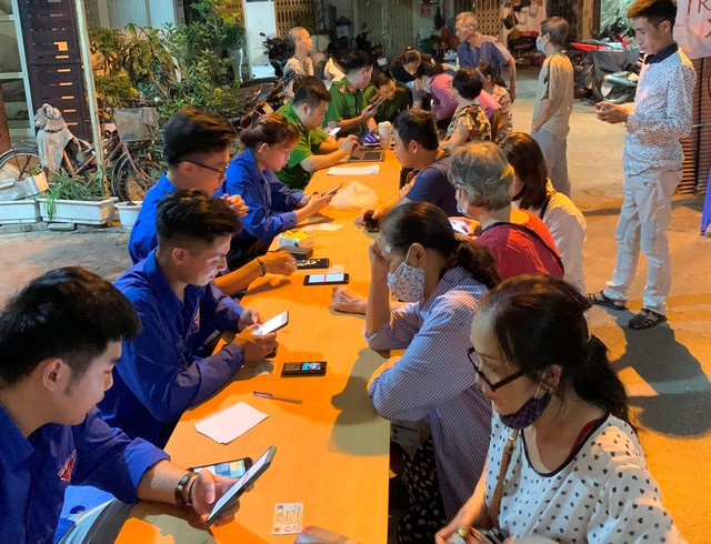 Đoàn viên, thanh niên hỗ trợ người dân cài đặt tài khoản định danh điện tử. Ảnh: NGUYỆT ÁNH