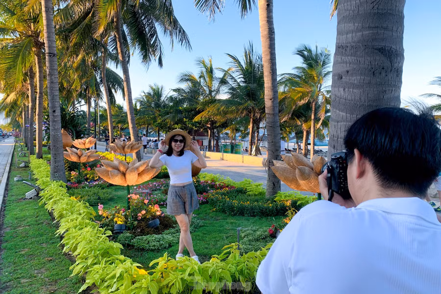 Nhiều du khách thích thú đi dạo trên đường hoa ven biển, cùng nhau tạo dáng, chụp hình.