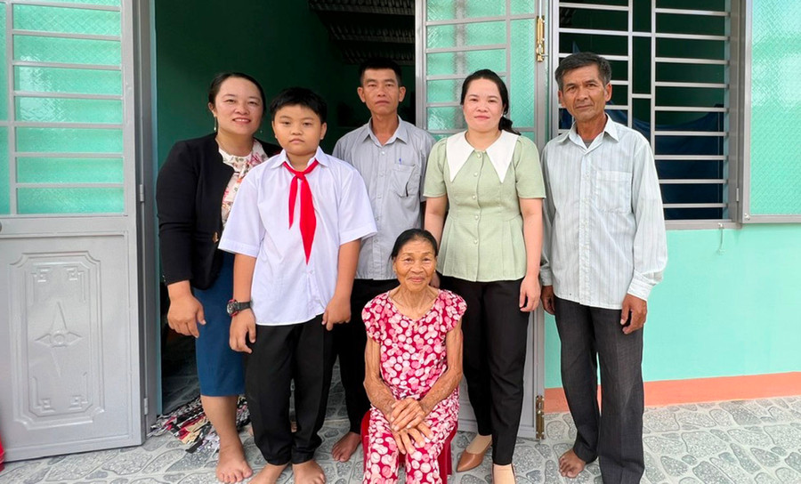 Bà Trần Thị Thanh (người ngồi, thôn An Xuân 1) vui mừng khi có nhà ở mới. Ảnh: Đ.Y