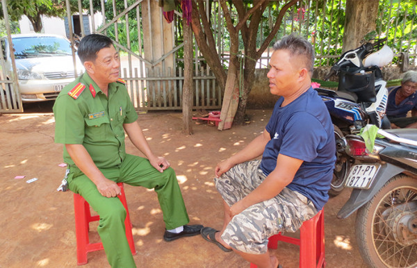 Trung tá Cao Minh Nghĩa và Phó trưởng thôn Đinh Jun trao đổi công việc.