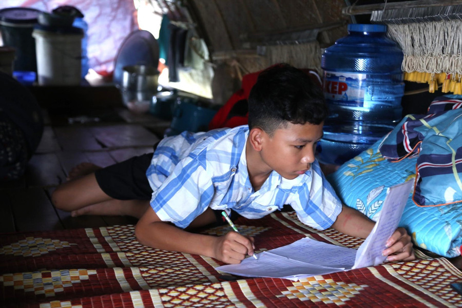 Không có bàn học, người con trai thứ hai của ông Hoài đang nằm bẹp dưới sàn thuyền để học bài. Không có bàn học, người con trai thứ hai của ông Hoài đang nằm bẹp dưới sàn thuyền để học bài.