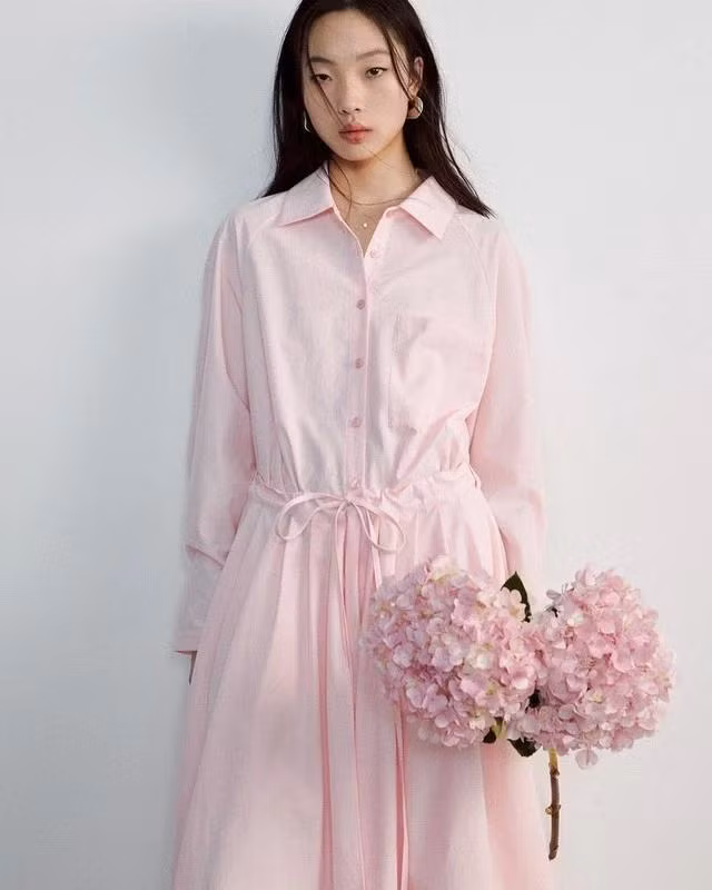 Chất vải cotton có sự mộc mạc và thô nhám nhẹ trên bề mặt vải nên rất dễ nhận ra. Những thiết kế váy sơ mi cotton đơn sắc trên những tông nhạt mang đến cảm giác dễ chịu và thông thoáng hơn vào mùa hè. Gợi ý mặc đẹp cho nàng từ chất vải tự nhiên này là mẫu đầm hồng pastel bổ sung dây buộc eo có thể điều chỉnh dễ dàng và thuận tiện. Ảnh Formal Studio