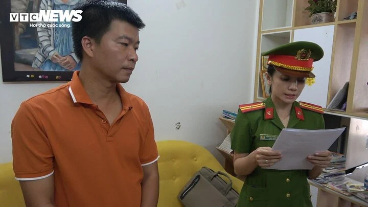 Cán bộ công an đang tuyên đọc các quyết định khởi tố, bắt giam với Phạm Hoàng Liên. (Ảnh: Công Quang)