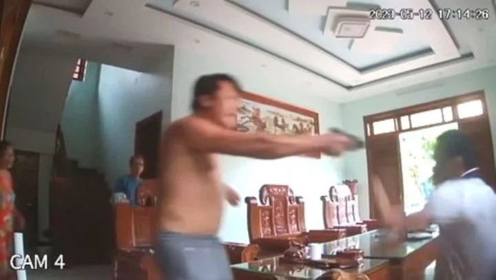 Quý dí súng vào đầu, uy hiếp chủ nhà. (Ảnh: Cắt từ clip) Quý dí súng vào đầu, uy hiếp chủ nhà. (Ảnh: Cắt từ clip)