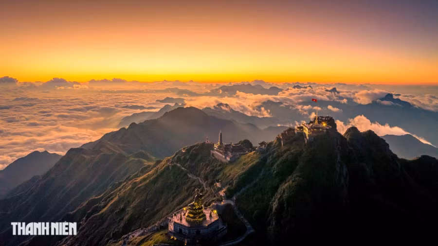 Đỉnh Fansipan nằm trong Khu du lịch Sun World Fansipan Legend thuộc thị xã Sa Pa, tỉnh Lào Cai và cách Sa Pa khoảng 7 km về phía tây nam. Để chinh phục đỉnh núi, du khách có hai lựa chọn là đi cáp treo hoặc leo bằng đường bộ. Khung cảnh hừng đông nhuộm màu mây sớm là một trong những khoảnh khắc không thể quên đối với bất kỳ du khách nào có cơ hội ngắm được. Ảnh: BÙI VĂN HẢI