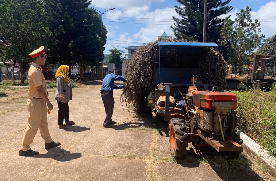 Công an huyện Đak Đoa nhắc nhở chủ xe công nông chở hàng cồng kềnh, che khuất tầm nhìn. Ảnh: Lê Anh