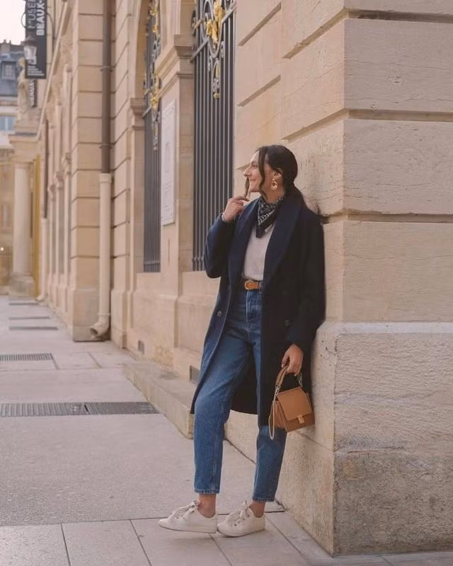 Áo khoác dạ màu xanh đen có phom ngắn chấm đầu gối thích hợp mặc trong tiết trời se lạnh nhẹ nhàng. Món đồ này kết hợp cùng quần denim xanh tạo nên diện mạo vừa năng động vừa trẻ trung đậm chất gen Z. Để tạo điểm nhấn cho trang phục, có thể phối thêm khăn lụa họa tiết tông xanh đen, phụ kiện màu nâu đi cùng áo và giày màu sáng