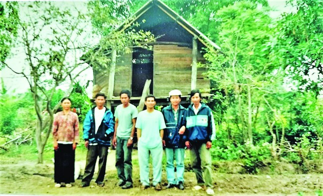Tác giả (đội mũ, thứ hai từ phải qua) cùng một số cán bộ, người dân địa phương trước căn nhà bà Ksor H’BleKsor H’Ble. Ảnh chụp chiều 29/12/2021.