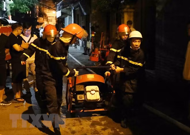Lực lượng phòng cháy chữa cháy và cứu nạn cứu hộ đưa thiết bị chuyên dụng tiếp cận đám cháy. (Ảnh: Phạm Kiên/TTXVN)