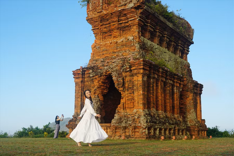 Du khách chụp hình kỉ niệm tại tháp Bánh Ít. Ảnh: Thanh Chân