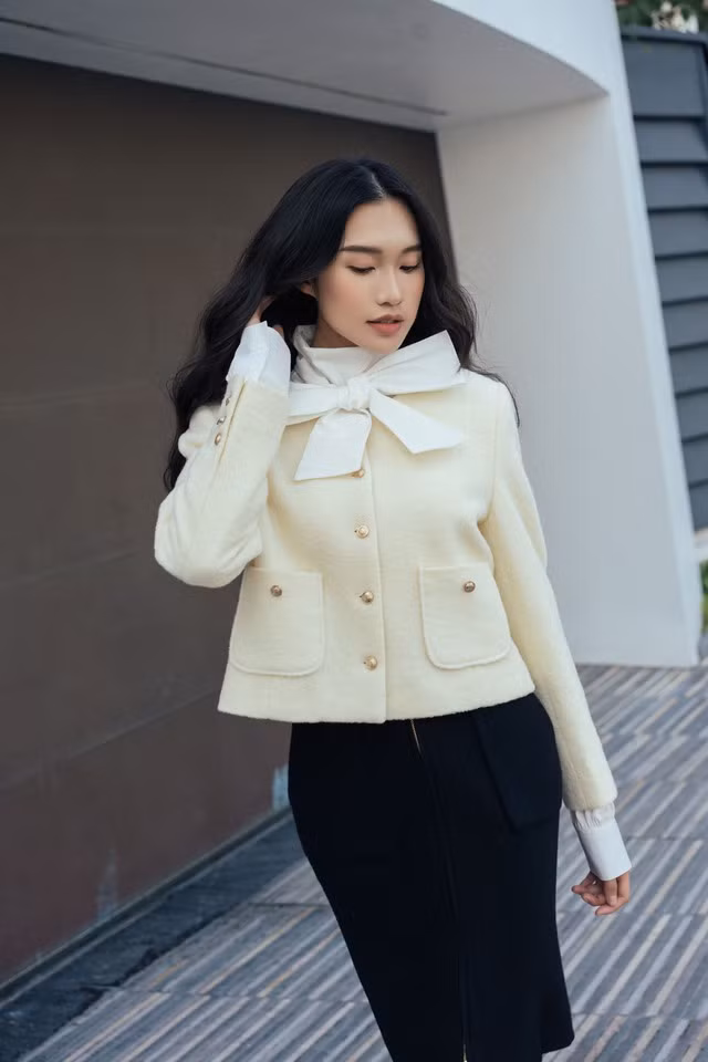 Kết hợp hai tone màu kinh điển là đen, trắng sữa, ngoài lợi thế thiết kế sáng tạo thì phụ kiện nơ xinh xắn khiến vẻ đẹp của người đẹp trường Luật thật trẻ trung, cuốn hút