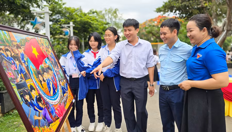 Nhóm tác giả Trường THCS Lý Tự Trọng trao đổi về nội dung bức tranh “Áo xanh về bản” với Ban tổ chức hội thi. Ảnh: M.N