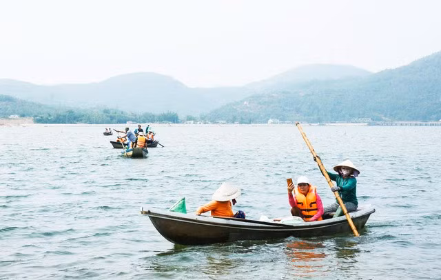 Bà Nguyễn Thị Xị (bìa phải) tham gia chèo ghe chở khách tham quan đầm An Khê (TX.Đức Phổ, Quảng Ngãi). Ảnh: Hải Phong