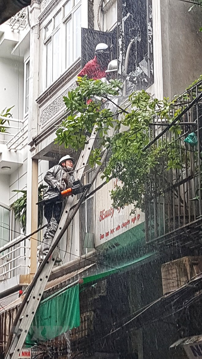 Lực lượng chức năng phải phá cửa để đưa vòi nước vào trong nhà dập lửa. (Ảnh: Tuấn Anh/TTXVN)