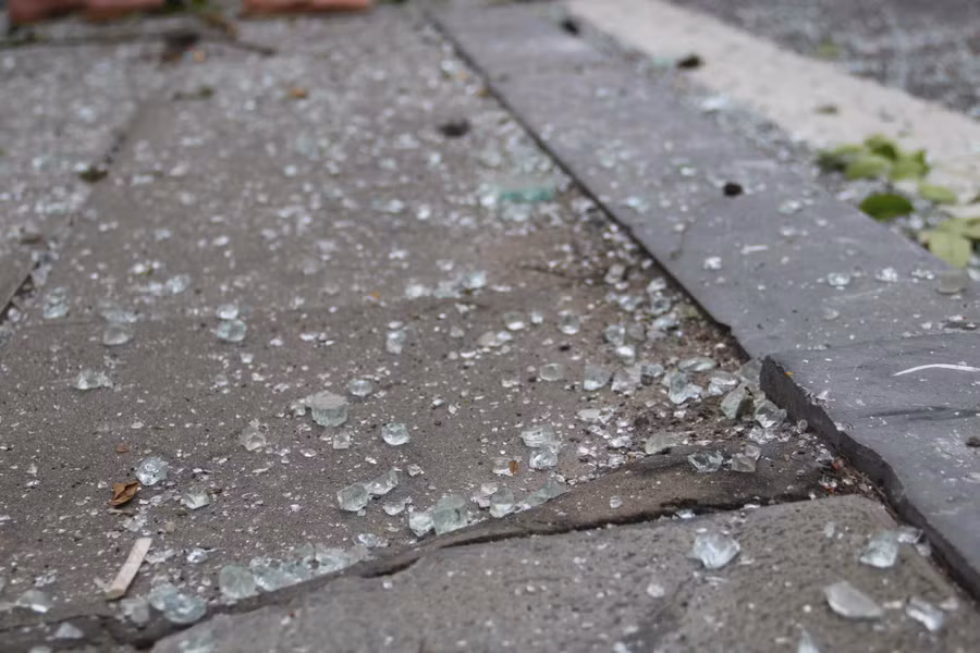 Mảnh kính vỡ văng xa ra đường và vỉa hè. Ảnh: Khánh Linh.