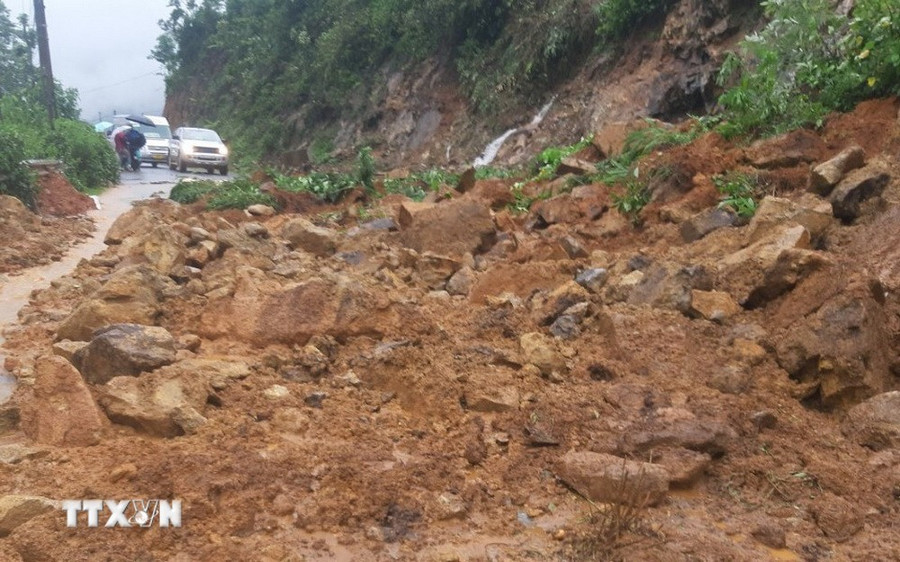 Các đơn vị tập trung nhân lực, máy móc, hót dọn đất đá và các chướng ngại vật trên lề đường, mặt đường. (Ảnh: TTXVN phát)