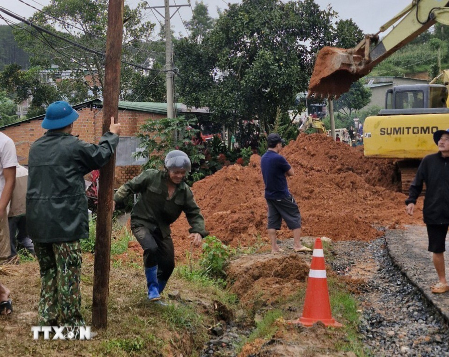 Lực lượng chức năng cùng thiết bị cơ giới triển khai công tác cứu hộ, giải tỏa hiện trường. (Ảnh: TTXVN phát) Lực lượng chức năng cùng thiết bị cơ giới triển khai công tác cứu hộ, giải tỏa hiện trường. (Ảnh: TTXVN phát)
