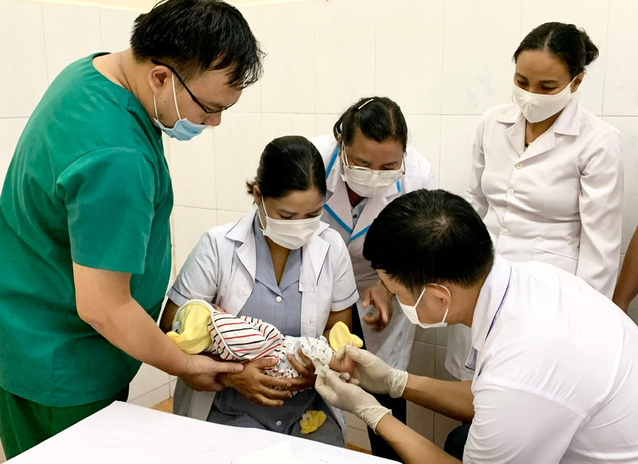 Bác sĩ chuyên khoa I Hồ Quang Tiến (bìa trái)-Khoa Sản (Bệnh viện Đa khoa tỉnh) hướng dẫn các học viên kỹ thuật lấy máu gót chân trẻ sơ sinh. Ảnh: N.N