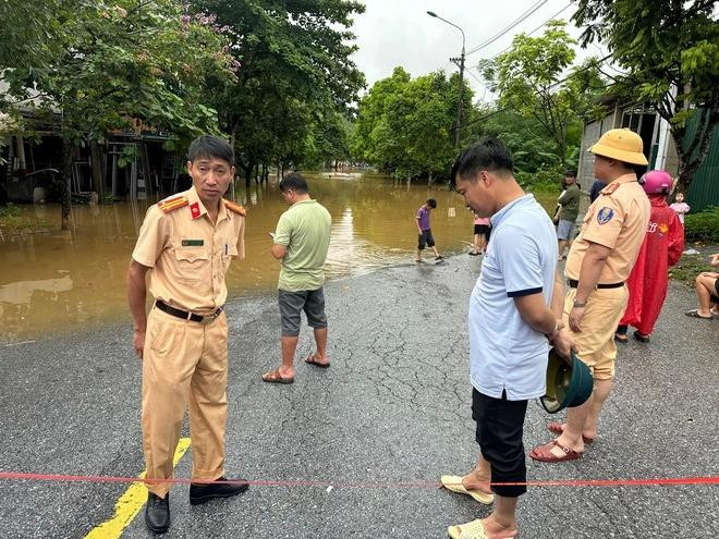Lực lượng CSGT ứng trực phân luồng, giúp người dân trong mưa lũ. Ảnh: HỒNG MINH Lực lượng CSGT ứng trực phân luồng, giúp người dân trong mưa lũ. Ảnh: HỒNG MINH
