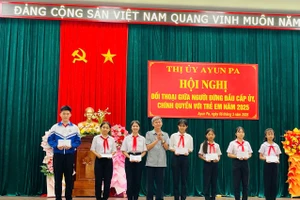 Bí thư Thị ủy Ayun Pa Trần Quốc Khánh tặng quà cho các em thiếu nhi tham gia hội nghị đối thoại. Ảnh: Vũ Chi