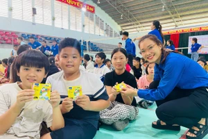 Chị Rah Lan H’Thùy (Bí thư Chi đoàn tổ dân phố 6) tặng quà cho các em nhỏ tham gia sinh hoạt hè. Ảnh: Vũ Chi