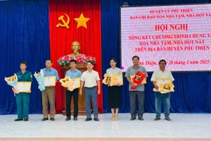 Ông Trần Trung Hiếu (đứng giữa, Bí thư Huyện ủy, Trưởng ban Chỉ đạo xóa nhà tạm, nhà dột nát huyện) tặng giấy khen cho các tập thể có thành tích xuất sắc trong thực hiện phong trào xóa nhà tạm, nhà dột nát trên địa bàn huyện. Ảnh: Vũ Chi