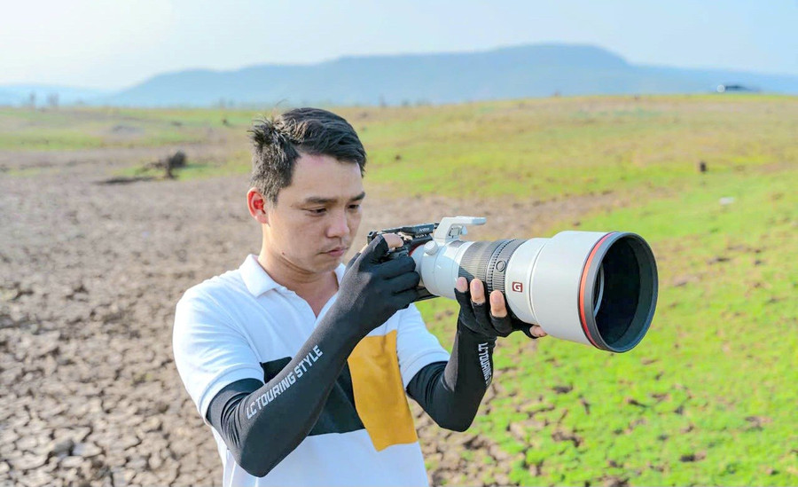 Phạm Công Quý say mê với chiếc máy ảnh trên một chuyến tác nghiệp. Ảnh: NVCC img-20251001-134805-1.jpg