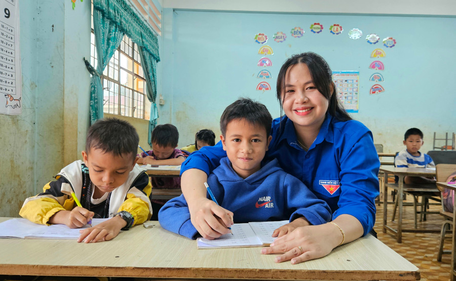 Chị Vũ Phạm Ngọc Hà-Giáo viên tình nguyện dạy lớp học hè tại xã Đak Sơ Mei tận tình hướng dẫn các em những nét chữ đầu tiên. Ảnh: Ngọc Duy 20250707-093416.jpg