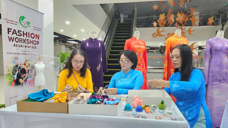 Nhà thiết kế Nguyễn Hạnh (giữa) cùng các thành viên Câu lạc bộ Áo dài Sống Xanh Pleiku chuẩn bị sản phẩm mini size tại sự kiện. Ảnh: Ngọc Duy 20250830-093116.jpg