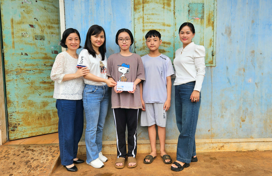 Chị Đỗ Thị Thùy (thứ hai từ trái sang) trao tiền hỗ trợ cho em Phạm Kiều Vy (THCS Lê Văn Tám) là học sinh vượt khó học giỏi. Ảnh: Ngọc Duy 20250706-113610.jpg