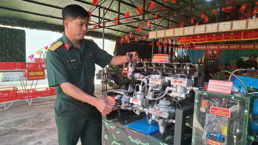 Thiếu tá Hoàng Đình Hình bên những sáng kiến cải thiện kỹ thuật của mình đang được trưng bày ở đơn vị. Ảnh: T.D eb5b6df559e9ebb7b2f8.jpg