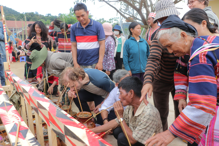Dân làng cùng du khách thưởng thức những ghè rượu cần ngọt thơm. Ảnh: Ngọc Minh img-6109.jpg