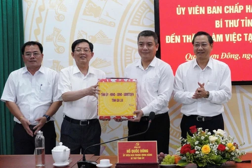 Bí thư Tỉnh ủy Hồ Quốc Dũng (thứ 2 từ trái sang) tặng quà cho lãnh đạo phường Quy Nhơn Đông. Ảnh: Nguyễn Hân